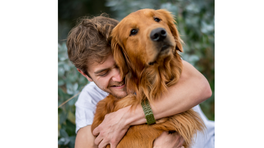 A man hugging a dog and happy